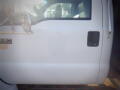 A white 2007 Ford F-650 truck with a distinctive side mirror and a large door handle