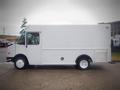 A white 2003 Freightliner MT45 Chassis with a boxy design and roll-up door on the side visible in a side view