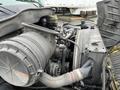 A close-up of a dusty engine compartment of a 2007 International 4300 showing various components including the air filter and belts