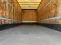 Interior of a 2013 International 4300 box truck with wooden walls and a flat metal floor