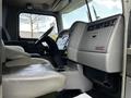 Interior view of a 2014 Kenworth T370 showing a driver's seat dashboard and steering wheel with controls and instruments