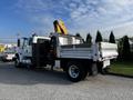 A 2013 International DuraStar 4300 utility truck with a flatbed and mounted crane on the rear side