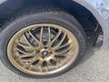 A close-up view of a gold alloy wheel and tire from a 1966 Ford Mustang showcasing intricate spoke design and brand markings