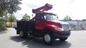 A red 2010 International 4400 truck with a bucket lift attached on the top and a utility bed in the rear