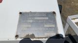 A weathered inspection plate attached to a 2011 Ford F-450 SD providing details on unit number and inspection history