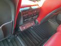 Interior view of a 2023 Acura MDX featuring red leather seats and control panel with climate and heated seat buttons