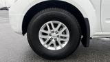 A close-up view of a 2016 Nissan Frontier's front wheel showcasing its alloy rim and Michelin tire