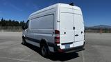 A 2016 Mercedes-Benz Sprinter van with a white exterior and a high roof viewed from the rear angle