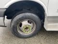 Close-up of a tire and wheel from a 2012 Chevrolet Express showing the rim and lug nuts with visible tread on the tire