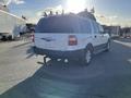 A white 2013 Ford Expedition parked with a visible tow hitch and rear view showing the vehicle's design and rear lights