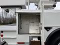 A compartment on a 2007 International 4200 showing two hooks mounted on the interior wall and a dirty floor with no visible items inside