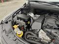 Under the hood of a 2018 Jeep Grand Cherokee showcasing the engine compartment with visible components including the battery and various engine parts