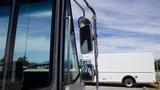 2011 Ford Econoline with a side mirror and door partially open showing its metallic frame and reflective glass