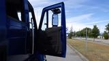 A blue 2012 International DuraStar 4300 truck with its driver's side door wide open, showcasing the interior cabin and dashboard design