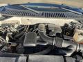 Engine compartment of a 2013 Ford Expedition featuring various components such as the air intake manifold and multiple hoses and connectors
