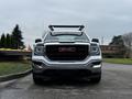 Front view of a 2018 GMC Sierra 1500 with a chrome finish and a prominent red GMC logo on the grille