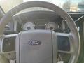 The steering wheel and dashboard of a 2013 Ford Expedition with speedometer and fuel gauge dials visible