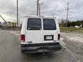 A white 2001 Ford Econoline van with a black bumper and a rear license plate marked VR-3152