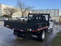 A 2017 Ford F-350 SD with a black flatbed and a mesh rear guard parked with an amber light on top and various lights along the back