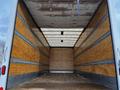 Interior of a 2022 Ford F-750 cargo truck with wooden walls and a flat metal floor, designed for transporting goods