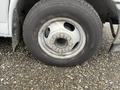 A close-up view of a tire mounted on a silver 2017 Chevrolet Express with visible wheel lug nuts and a textured tread pattern