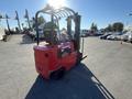 A red 2013 Raymond forklift with a black seat and safety guard positioned for loading or unloading pallets