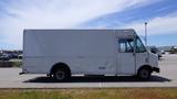 A white 2011 Ford Econoline cargo van parked in a lot with a sliding door on the side and a simple design