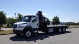 A white 2017 Freightliner M2 106 flatbed truck with a hydraulic crane mounted on the rear and three axles