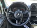 A 2022 Mercedes-Benz Sprinter steering wheel featuring controls for audio, cruise, and phone with a prominent Mercedes-Benz emblem in the center