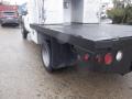 A 2009 Ford F-450 SD with a flatbed design featuring round red tail lights and a black sidewall tire