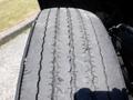 A close-up view of a worn tire from a 2008 Peterbilt 335 showing significant tread wear and grooves on the surface