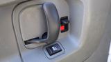 A close-up of the door handle and window control of a 2012 GMC Savana showing a black handle and a button for the window