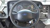 The interior view of a 2011 Ford Econoline showing the steering wheel dashboard gauges and control buttons