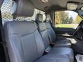 Interior view of a 2016 Ford F-350 SD showing gray leather seating with two headrests and a partition behind the seats