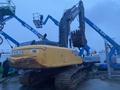 A 2014 John Deere 350G excavator with a yellow body and large black arm attached to a bucket is positioned in the foreground