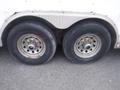 A pair of weathered tires mounted on a metal rim attached to a 2010 Forest River Enclosed trailer