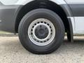 A close-up of a tire on a 2017 Mercedes-Benz Sprinter showing a silver rim with circular holes and a black Bridgestone tire tread