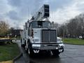 A 2011 Western Star Trucks 4900 with an elevated bucket and distinctive grille design parked on a roadway