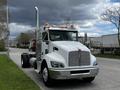 White 2014 Kenworth T370 truck with chrome accents and tall exhaust stacks parked on the street