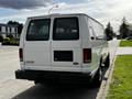 A white 2004 Ford Econoline van parked with a blank rear license plate and no visible markings on the back