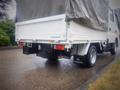 A white 2003 Toyota Toyoace truck with a covered cargo bed and visible Toyota branding on the rear and side