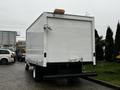 A white 2017 Ford Econoline cargo van viewed from the rear showing its flat back and dual rear wheels