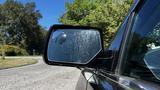 A 2018 Chevrolet Tahoe with a focus on the driver's side mirror reflecting the surrounding area