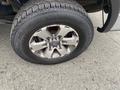 A close-up of a silver alloy wheel with a flat tire on a 2014 Ford F-150 showing the tread and rim details