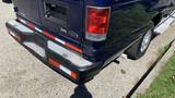 A blue 2013 Ford Econoline van showing the rear bumper with taillights and a license plate area