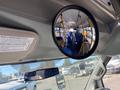 A 2017 Chevrolet Express interior view showing a circular mirror reflecting the bus seating and aisle