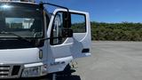 A white 2006 Ford LCF 550 truck with an open driver's side door and a visible side mirror