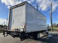 A 2013 International 4300 box truck with a white cargo area and visible lift gate at the rear