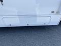 A white 2012 Ford Econoline with a plain exterior design featuring a smooth panel and a couple of visible latch points