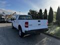 A white 2008 Ford F-150 XL pickup truck with a bed and four doors viewed from the rear